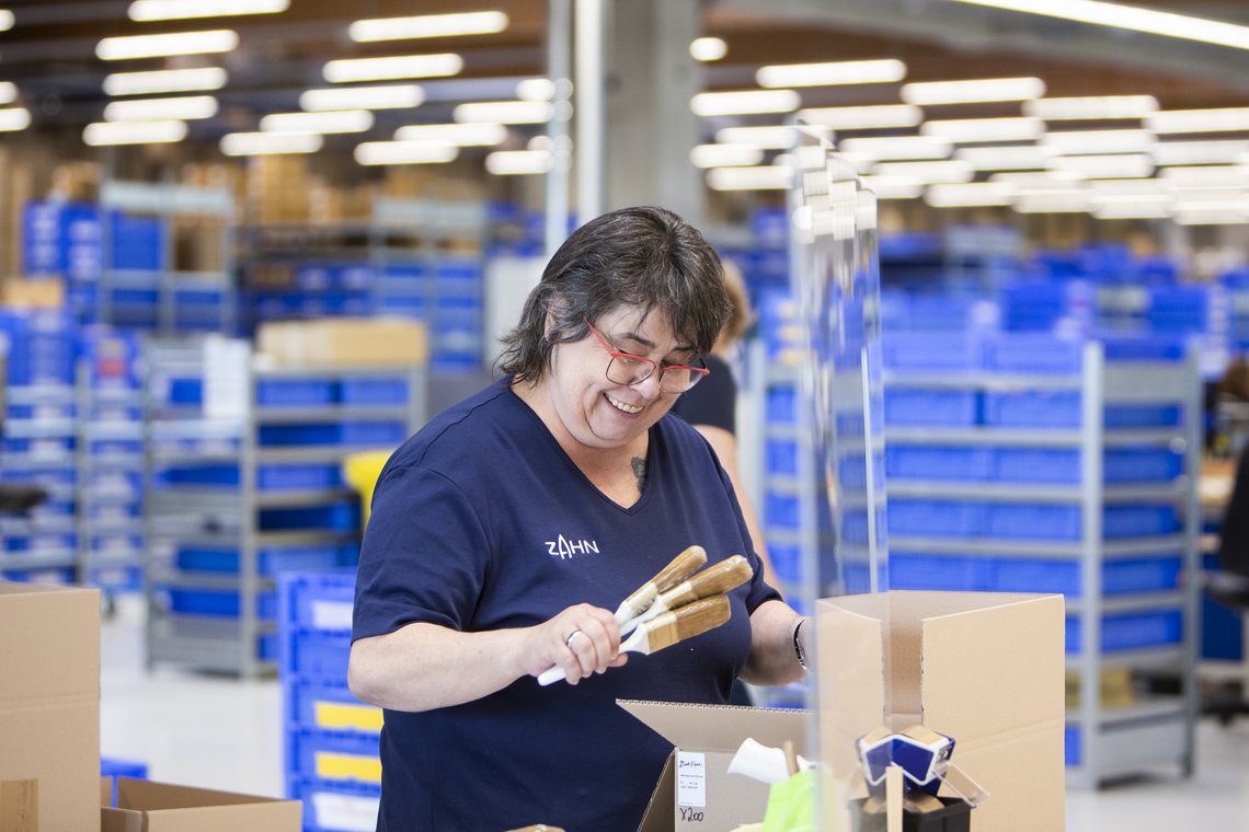 Mitarbeiterin mit Pinseln in der Hand